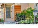 Condo entryway with gray door and surrounding shrubs at 144 Wild Palm Dr, Bradenton, FL 34210