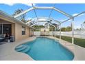 Freeform swimming pool with screened enclosure and backyard access at 1577 Taggard Rd, North Port, FL 34288