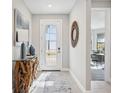 Bright entryway with glass front door, wood-look floors, and a unique console table at 17530 Northwood Pl, Bradenton, FL 34202