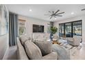 Spacious living room with large windows, comfortable seating, and a modern TV stand at 17530 Northwood Pl, Bradenton, FL 34202