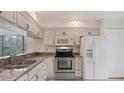 Bright kitchen featuring white cabinets, stainless steel appliances, and granite countertops at 3102 Windrush Bourne # 4, Sarasota, FL 34235
