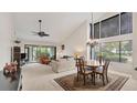 Bright living room with high ceilings, large windows, and a dining area with a chandelier at 3102 Windrush Bourne # 4, Sarasota, FL 34235