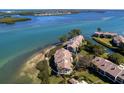 Aerial view of waterfront condo building showcasing private balconies and lush landscaping at 3860 Mariners Way # 413, Cortez, FL 34215