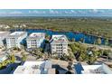 Aerial view of condo building near water with parking and tropical foliage at 395 Aruba Cir # 302, Bradenton, FL 34209