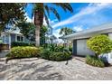 Cobblestone driveway, lush landscaping, and garage at 409 Casey Key Rd, Nokomis, FL 34275
