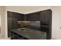 Modern kitchen with dark wood cabinets, marble island, stainless steel appliances at 4950 Remington Dr # 403, Sarasota, FL 34234