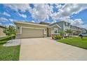 Tan house with a two-car garage and nicely landscaped yard at 5282 Grove Mill Loop, Bradenton, FL 34211