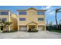 Bright yellow two-story home with two-car garage and nicely landscaped at 653 Cedars Ct, Longboat Key, FL 34228