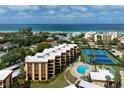Aerial view of condo complex with oceanfront location, pool and tennis at 8773 Midnight Pass Rd # 205G, Sarasota, FL 34242