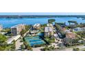 Aerial view of waterfront condo community with pool and tennis courts at 8773 Midnight Pass Rd # 205G, Sarasota, FL 34242