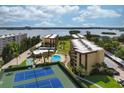 Aerial view of condo building, pool, tennis courts, and waterfront at 8773 Midnight Pass Rd # 205G, Sarasota, FL 34242