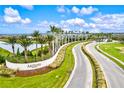 Aerial view of Artistry community entrance with palm trees and lake at 9085 Bernini Pl, Sarasota, FL 34240