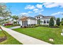 Modern house with gray garage door and lush green lawn at 9085 Bernini Pl, Sarasota, FL 34240