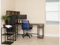 Home office features a corner desk, shelving, and window at 9814 Daybreak Gln, Parrish, FL 34219