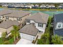 Two-story house with gray siding, brown roof, and a two-car garage near the water at 10128 Milky Way Cir, Sarasota, FL 34241