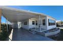 Front view of a white mobile home with carport and landscaping at 10315 Cortez W Rd # 37F, Bradenton, FL 34210