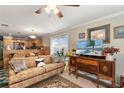 Living room features a comfy couch, antique wood cabinet, and a large TV at 1106 49Th Avenue W Dr, Bradenton, FL 34207