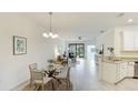 Bright living room with tile floors, natural light, dining table, and a view of the outdoor space at 12651 Garibaldi Ln, Venice, FL 34293