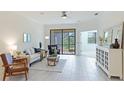 Inviting living room featuring tile floors, a comfortable sofa, and access to the screened lanai at 12651 Garibaldi Ln, Venice, FL 34293