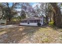 House with mature trees, grassy yard, and a screened porch at 1376 18Th St, Sarasota, FL 34234