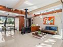 Bright living room with wood beams, modern fireplace, light colored floors, and stylish furnishings at 1695 Lowe Dr, Sarasota, FL 34236