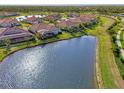 Community overview featuring houses with red tile roofs and a lake at 20107 Uffizi Ct, Venice, FL 34293