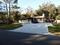 Front view of a single story home with a large driveway at 219 E Early St, Brooksville, FL 34601