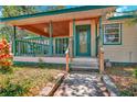 Inviting front porch with wooden flooring and green railings at 29199 Livingston Dr, Punta Gorda, FL 33982