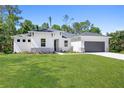 White house with gray garage and stone accents at 3490 Ikola Ave, North Port, FL 34288