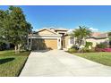 Single-story home with tan exterior, landscaping, and a two-car garage at 4422 Legacy Ct, Sarasota, FL 34241