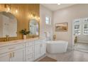 Elegant bathroom featuring double vanities, a soaking tub, and gold hardware at 5097 Faberge Pl, Sarasota, FL 34233