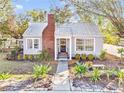 Charming bungalow with metal roof, brick chimney, and landscaped yard at 514 Riverside E Dr, Bradenton, FL 34208