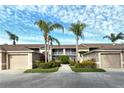 Condo building exterior with palm trees and landscaping at 5281 Mahogany Run Ave # 822, Sarasota, FL 34241
