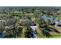 Aerial view of lakefront home with large lot and mature trees at 6300 26Th E Ave, Bradenton, FL 34208