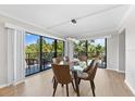 Modern dining area with glass table and leather chairs, near sliding glass doors at 6326 Midnight Pass Rd # 101, Sarasota, FL 34242