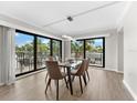 Dining room features a glass table and six brown leather chairs, with access to a balcony at 6326 Midnight Pass Rd # 101, Sarasota, FL 34242