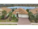 Single-story house with a lake view, tile roof, and two-car garage at 7036 Whittlebury Trl, Bradenton, FL 34202