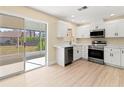 Modern kitchen with white cabinets, stainless steel appliances, and light wood floors at 727 N Jefferson Ave # 727, Sarasota, FL 34237