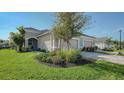 Tan house with two-car garage and landscaped lawn at 7668 Registrar Way, Sarasota, FL 34243