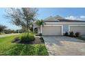 Tan two-car garage house with gray paver driveway at 7668 Registrar Way, Sarasota, FL 34243