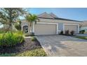Tan two-car garage house with gray paver driveway at 7668 Registrar Way, Sarasota, FL 34243