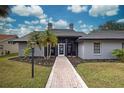 Front entry of single story home with walkway and landscaping at 1051 Truman St, Nokomis, FL 34275