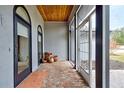 Covered porch with brick flooring, terracotta pots, and access to the house at 1051 Truman St, Nokomis, FL 34275