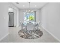 Modern dining area with round table and gray chairs, near kitchen at 120 Edgewater Ter, Dunedin, FL 34698