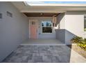 Renovated front entry features a pink door and a covered porch at 120 Edgewater Ter, Dunedin, FL 34698