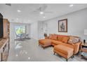 Bright living room with orange sectional sofa and polished concrete floors at 120 Edgewater Ter, Dunedin, FL 34698