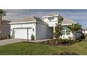 White one-story house with gray roof, two-car garage, and landscaped lawn at 16415 Isola Pl, Bradenton, FL 34211