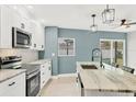 Updated kitchen with white cabinets, stainless steel appliances and an island at 2430 Sunnyside Ln, Sarasota, FL 34239