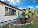 Front entrance with landscaping and a bright green door at 2586 Tami Sola St, Sarasota, FL 34237