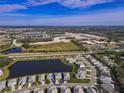 Aerial view of a house in a neighborhood with a lake at 3704 Wild Blossom Pl, Parrish, FL 34219